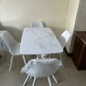 4-seater all-white dining set with marble top table and Eames chairs in a modern minimalist dining room