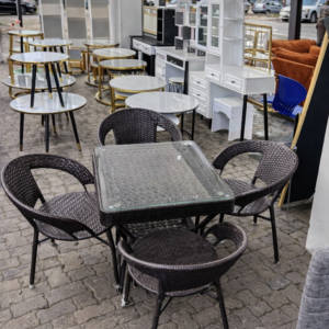 4-seater square glass top outdoor dining set with wicker chairs arranged neatly on a modern patio