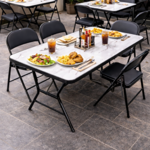 Foldable 4-seater dining table with black chairs and marble-pattern tabletop in an outdoor restaurant setup.