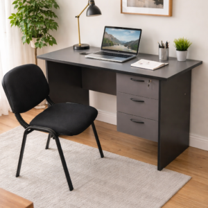 Compact office desk with drawer and comfortable visitor chair in a modern workspace