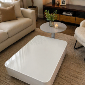 Cozy modern living room setup featuring a white glossy coffee table with a matching side table on a textured rug beside a neutral sofa.