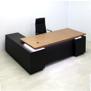Modern executive L-shaped office desk with wood top, black base, and LED accents in a stylish office setup.