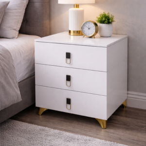Elegant white 3-drawer bedside table with gold accents and modern handles placed in a stylish bedroom setup.