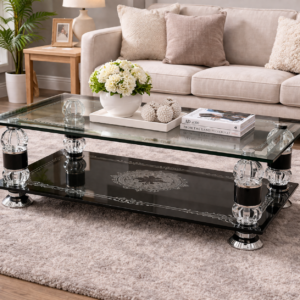 Elegant two-layer glass coffee table with etched patterns and chrome accents placed in a modern living room.