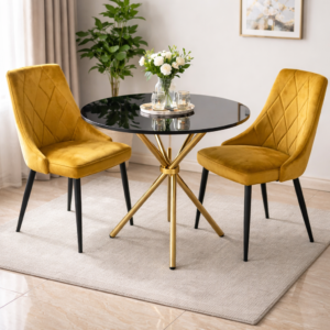 Elegant dining set with mustard velvet chairs and black glass round table with gold base in a modern home setup.