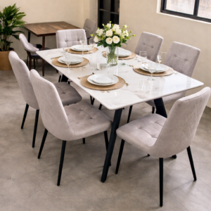 Modern marble-top dining table with upholstered chairs arranged in an elegant dining setup.