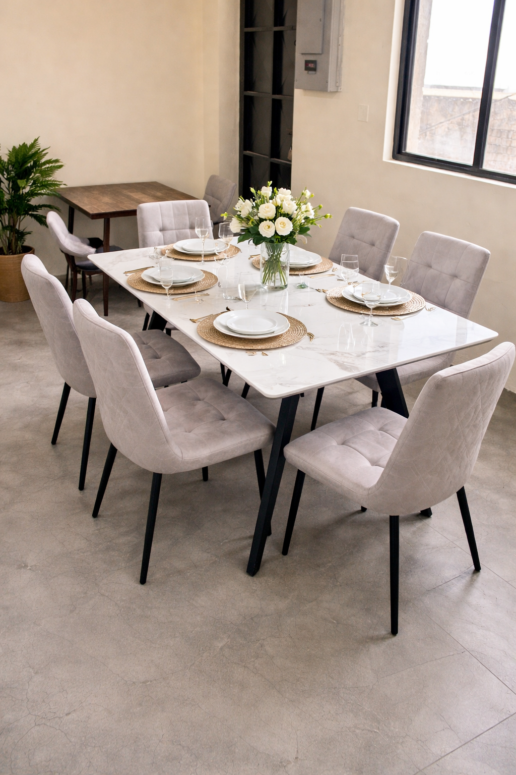Modern marble-top dining table with upholstered chairs arranged in an elegant dining setup.