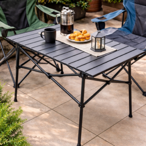 Foldable extendable outdoor table with black slatted top and metal frame set up on a patio