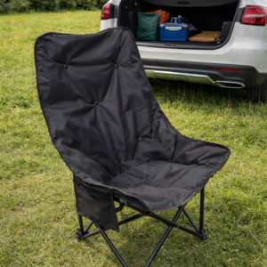 Medium size modern foldable camping chair in outdoor setup near car in green field