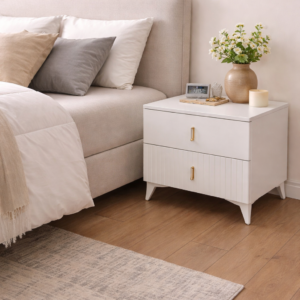Modern white bedside tables with drawers and gold handles placed beside a stylish bed in a contemporary bedroom setup.