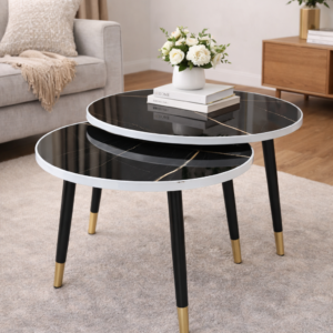 Modern double-layer round coffee table with black marble top and gold-accented legs in a living room setup