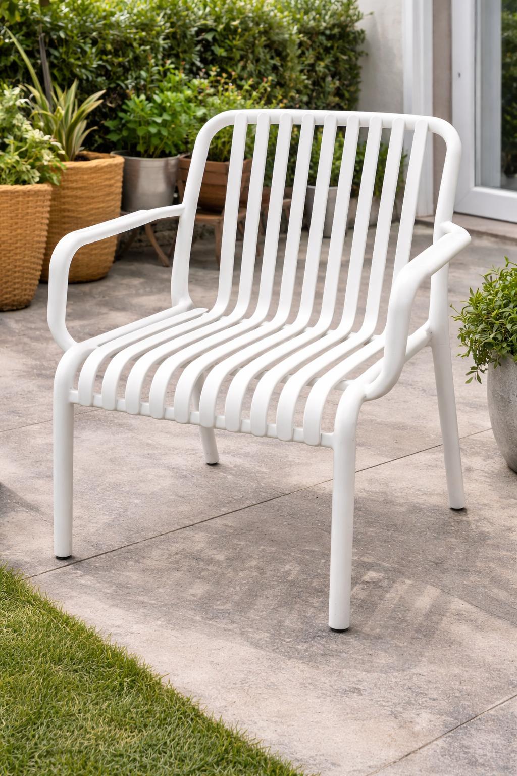 Modern white patio chair with slatted design placed in a stylish outdoor garden setting.