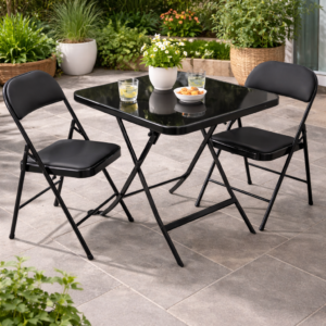 Outdoor patio setup with black folding table and chairs surrounded by greenery in a modern garden setting.
