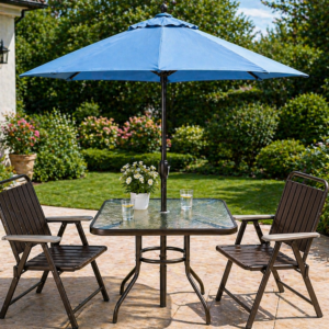 Outdoor square patio table with blurred glass top, two folding chairs, and blue umbrella in a garden setting