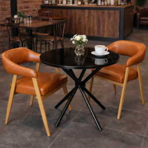 Round black glass table with modern faux leather accent chairs in a stylish café setup