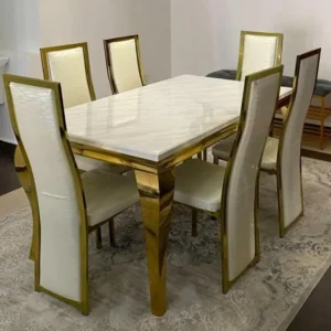 Premium gold-finish 6-seater dining table with marble top and upholstered chairs in a modern dining room